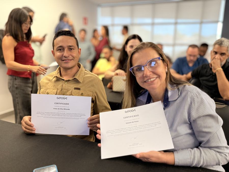 Dois participantes exibem seus certificados ao final da capacitação.